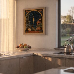 Moon phase wall art print hanging above a stone countertop with a fruit bowl in a sunny kitchen.