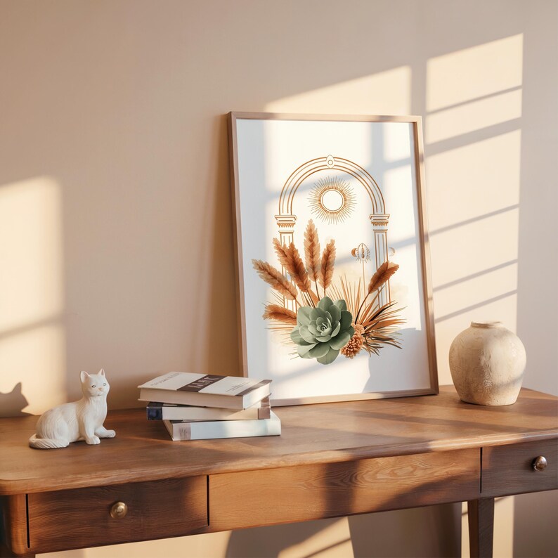 Pampas grass and succulent wall art framed on a dark vintage wooden desk with open books, ceramic vase, and natural window blind sunlight shadows cast across the wall, creating a peaceful home office reading nook decor.