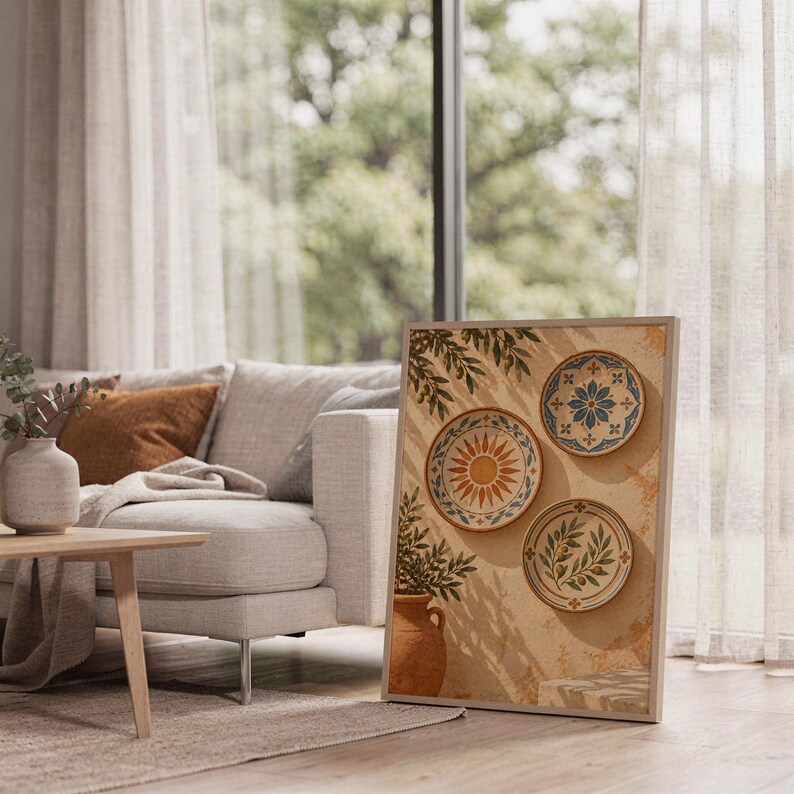 Mediterranean ceramic plate wall art print leaning on the floor beside a cream armchair next to large garden windows.