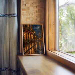 Paris eiffel tower wall art print standing on a wooden window sill in warm natural light.