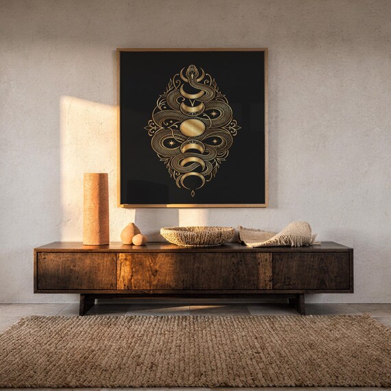 Gold snake moon phase wall art print hanging above a dark wood console and jute rug in a warm neutral interior.