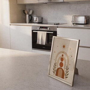 Mid century arch poster framed leaning on bright kitchen island counter in modern home.