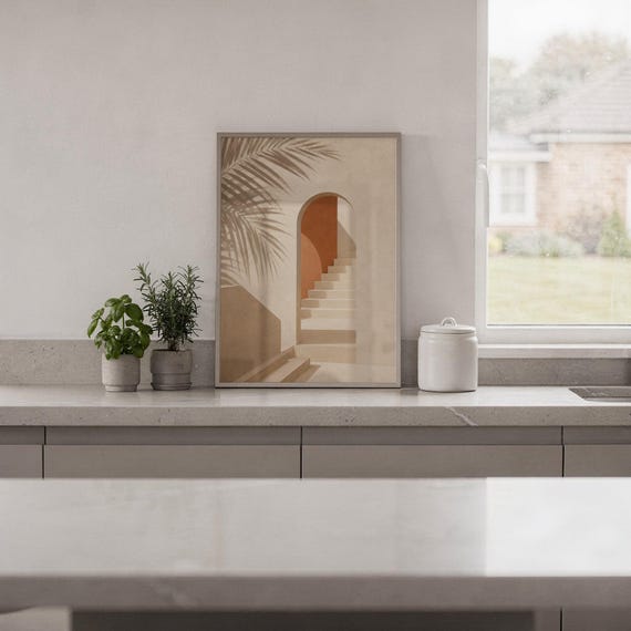 Terracotta arch art print resting on a countertop styled with indoor plants.