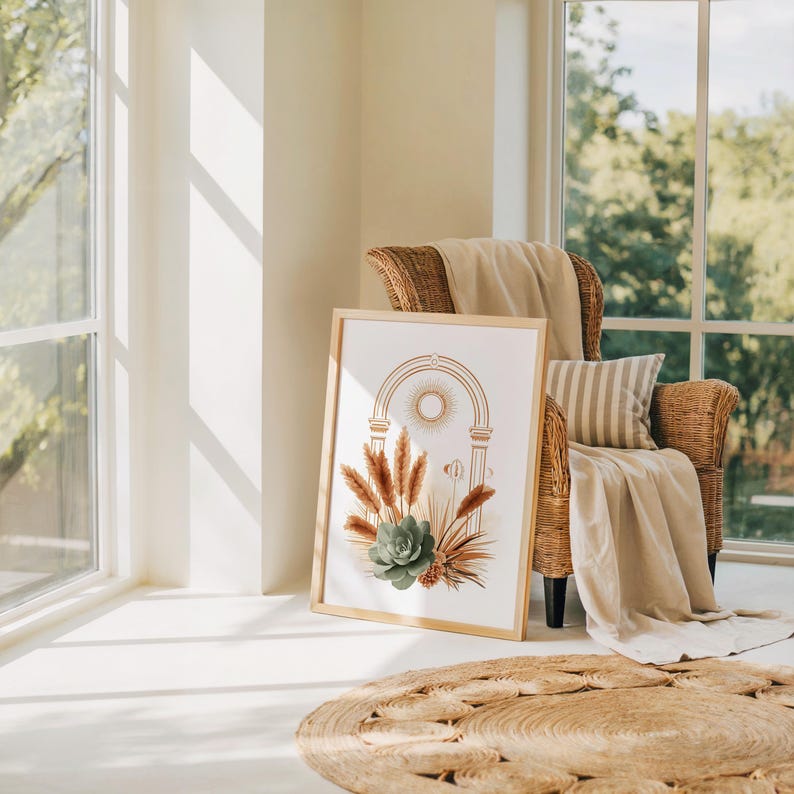Boho arch celestial sun poster resting on the floor in a bright sunlit living room with an armchair, soft throw blanket, round woven jute rug, and green houseplants for modern bohemian interior inspiration.