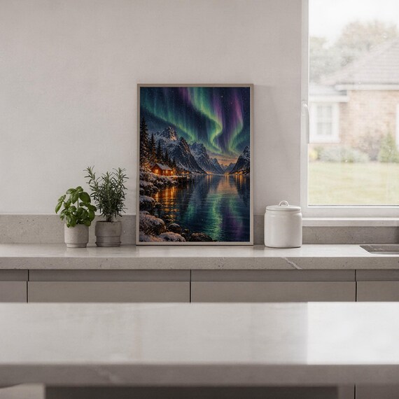 Aurora borealis mountain landscape wall art print standing on a white kitchen counter beside potted herbs.