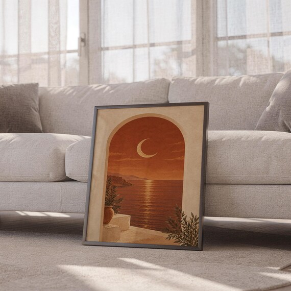 Mediterranean crescent moon arch print leaning against a white sofa in a bright living room with sheer curtains.