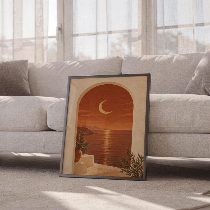 Mediterranean crescent moon arch print leaning against a white sofa in a bright living room with sheer curtains.