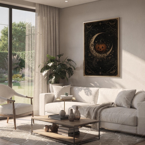 Vintage halloween moon wall art print hanging above a white sofa in a living room with garden views.