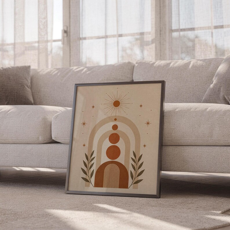 Boho arch and celestial star poster framed leaning against sofa in cozy sunlit living room setup.