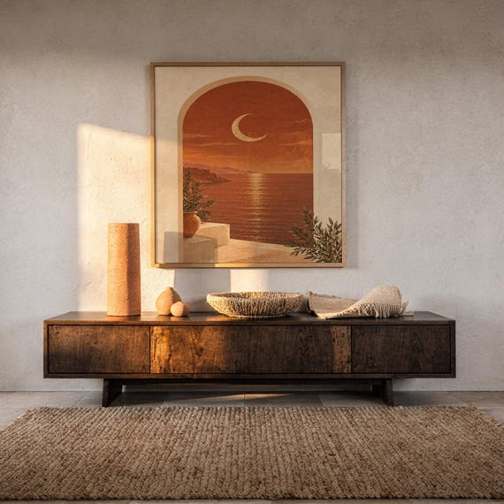 Mediterranean crescent moon arch print hanging above a dark wood console and jute rug in a warm neutral interior.