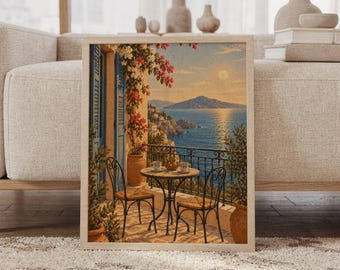 May include: A framed wall art print depicting a Mediterranean balcony scene at sunset. The image features a round table with two chairs, terracotta pots with blooming pink bougainvillea, and a view of the sea with distant mountains.