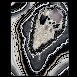 May include: A rectangular wall art piece featuring a black, white, and gray agate-inspired resin design. The center contains a cluster of clear, black, and faceted gray crystals embedded within a textured bed of crushed white and black glass.
