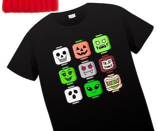 May include: A black t-shirt with a colorful graphic of Halloween-themed monster faces. A red knit beanie with a pom-pom and black sunglasses are also in the image. The Baby Batz logo is in the lower left corner.