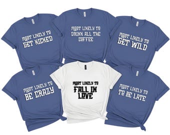 May include: A selection of blue and white t-shirts, each bearing a different white-printed phrase. The phrases read: "Most Likely To Get Kicked", "Most Likely To Drink All The Coffee", "Most Likely To Get Wild", "Most Likely To Be Crazy", "Most Likely To Fall In Love", and "Most Likely To Be Late".