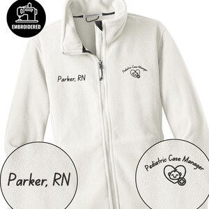 May include: A white fleece jacket with a full zipper and a stand-up collar. The jacket has the embroidered text "Parker, RN" on the left chest and "Pediatric Case Manager" with a heart and smiley face logo on the right chest. The top left corner has an embroidered sewing machine logo.