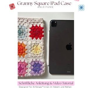 Könnte beinhalten: Eine handgefertigte Granny Square iPad-Hülle mit einem schwarzen iPad und Stift. Die Hülle hat ein Häkeldesign mit Quadraten in Rot, Orange, Gelb, Rosa, Lila und Türkis. Der Text auf dem Bild lautet "Granny Square iPad Case" und "Schriftliche Anleitung & Video Tutorial".