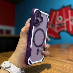 Może przedstawiać: Fioletowo-białe etui na telefon z przezroczystym tyłem. Etui ma okrągły wzór z tyłu i ochronny zderzak na krawędziach. Etui jest przeznaczone do smartfona.