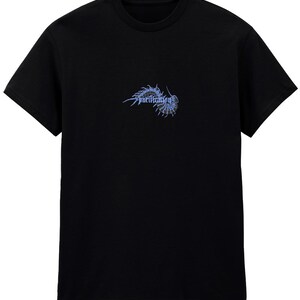 Puede incluir: Camiseta negra de cuello redondo con un dise&ntilde;o gr&aacute;fico azul y la palabra "purification" en una fuente estilizada. El gr&aacute;fico parece ser un insecto o criatura estilizada. La camiseta es de material suave.
