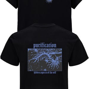 Puede incluir: Camiseta negra con la palabra "purification" en una fuente estilizada en la parte delantera y trasera. La parte trasera de la camiseta presenta un dise&ntilde;o rectangular azul con el texto "purification" y "hidden aspects of the self".