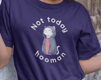 Könnte beinhalten: Marineblaues T-Shirt mit dem Text "Not today hooman" und einer Cartoon-Katze mit Kapuzenpullover. Die Katze ist grau mit einem rosa Hemd. Das T-Shirt wird mit hellblauen Jeans getragen.