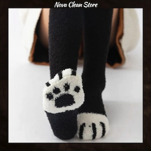 May include: Black and white fuzzy socks with a paw print design on the toes. The socks are knee-high and have the text "Nova Clean Store" at the top.