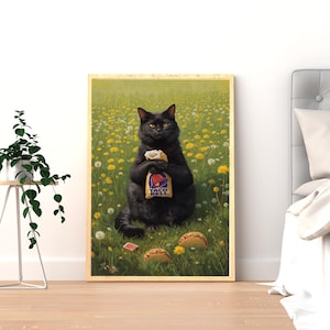 May include: A framed wall art print depicting a black cat sitting in a field of yellow dandelions and white seed heads. The cat holds a paper Taco Bell bag, with two taco shells resting on the grass in front of it. The print has a light wood frame.