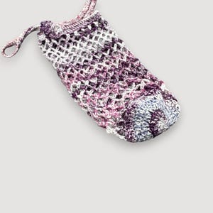 Peut inclure: Une pochette cylindrique en crochet présentant un motif de fil panaché dans des tons de violet, rose, blanc et bleu clair. La pochette possède un corps en maille ouverte, une base circulaire solide et une fermeture à cordon avec deux liens tressés.