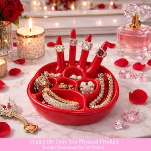May include: A red hand-shaped jewelry holder displaying rings and bracelets. The holder has slots for rings and compartments for other jewelry. The image also includes candles, rose petals, and a perfume bottle.