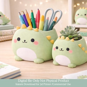 May include: Two light green dinosaur-shaped desk organizers, one holding pens and scissors, the other a succulent plant. The organizers have black eyes, pink cheeks, and yellow spines. A third dinosaur figure is in the background.