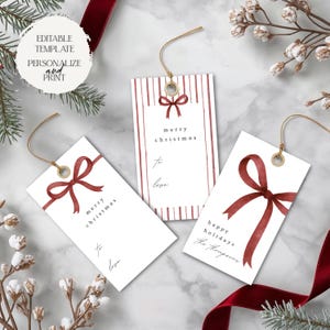 May include: White gift tags with red bows and text. One tag reads "Merry Christmas to love", another reads "Happy Holidays The Thompsons", and a third tag reads "Merry Christmas to love". The tags have gold string.