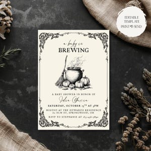 May include: A cream-colored baby shower invitation card featuring a black ink illustration of a steaming cauldron, a broom, and pumpkins. The text reads A baby is BREWING, A BABY SHOWER IN HONOR OF Julia Garcia, SATURDAY, OCTOBER 15TH AT 3PM.