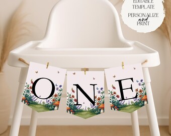May include: A banner spelling "ONE" is displayed on a high chair. Each pennant features a floral design with mushrooms, butterflies, and the letters O, N, and E in black. The banner is held by small gold clips.