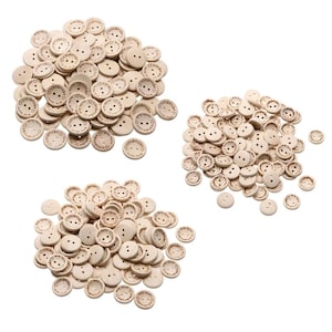 May include: A collection of small, round, wooden buttons with two or four holes. Each button has the words "handmade with love" and a small smiley face etched into the wood. The buttons are a light beige color.