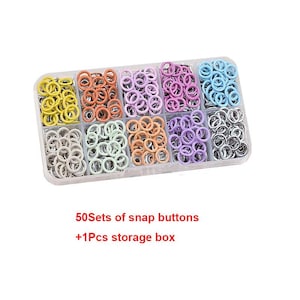 May include: A clear plastic storage box filled with sets of colorful snap buttons. The buttons are arranged in rows of yellow, orange, pink, purple, light blue, gray, green, peach, lavender, and silver. Text on the image reads: "50 Sets of snap buttons +1 Pcs storage box."