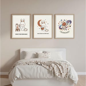 Puede incluir: Tres impresiones artísticas enmarcadas con conejos de dibujos animados. Uno pinta, otro lee y el último explora el espacio. El texto incluye "Create Your Own Magic", "sweet dreams my little heart" y "THE UNIVERSE AWAITS."
