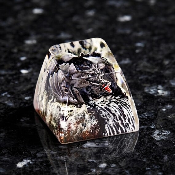 A tiny hand-sculpted dragon erupting from lava — a single keycap that turns any mechanical keyboard into a conversation piece.