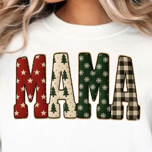 Könnte beinhalten: Weißes Sweatshirt mit dem Wort "MAMA" in einem festlichen Design. Die Buchstaben sind mit roten Sternen, Weihnachtsbäumen, Schneeflocken und einem schwarz-braunen Karomuster verziert. Ein gemütliches und stilvolles Oberteil für die Weihnachtszeit.
