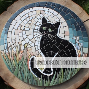 Puede incluir: Mosaico redondo que representa un gato negro con ojos verdes, sobre un fondo de luna y hierba estilizadas. El mosaico est&aacute; hecho de peque&ntilde;as baldosas de colores y est&aacute; colocado sobre una superficie de madera. El texto "EKmosaicTemplates" es visible.