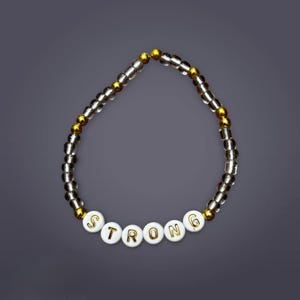 Pulsera fuerte de cuentas transparentes y doradas
