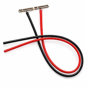 May include: A pair of electrical wires, one black and one red, each featuring a metallic cylindrical connector at one end. The wires are flexible and curved, with the black wire crossing over the red wire, and both connectors are positioned side by side at the top.