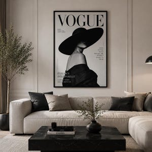 May include: A framed black and white wall art print featuring a Vogue magazine cover with a person wearing a wide-brimmed hat and an off-the-shoulder garment. The text includes the word VOGUE, PARIS, STYLE IS A WAY TO SAY WHO YOU ARE WITHOUT SPEAKING, and &Eacute;L&Eacute;GANCE INTEMPORELLE.