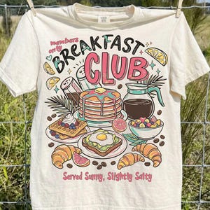 May include: A set of three ceramic mugs with a speckled, matte finish. The mugs are in shades of cream, light gray, and dark gray. Each mug has a simple, minimalist design, perfect for coffee or tea.