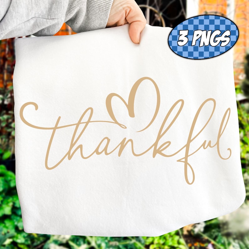 May include: A white fabric item with the word "thankful" in a cursive font, with a heart shape above the word. A blue oval with the text "3 PNGS" is in the upper right corner.