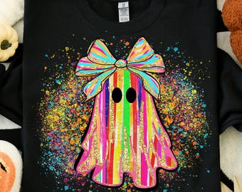 May include: Black sweatshirt featuring a colorful ghost design. The ghost is adorned with a rainbow bow and vertical stripes in various colors. The design includes a splatter effect with multiple colors, creating a vibrant and festive look.