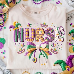 May include: Cream-colored t-shirt with the word "NURSE" in purple, gold, and green Mardi Gras-themed lettering. The design includes a bow, stethoscope, fleur-de-lis, and confetti. Decorative beads and masks surround the shirt.