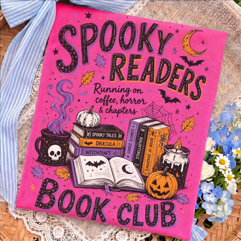May include: A bright pink t-shirt featuring a graphic print with the text SPOOKY READERS BOOK CLUB and Running on coffee, horror & chapters. The design includes a skull mug, stacked books titled Spooky Tales, Dracula, Witchcraft, Ghost Stories, Hauntings, and Book of Shadows, a jack-o'-lantern, a candle, bats, and autumn leaves.