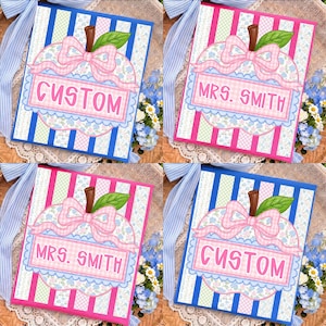 May include: Four square signs featuring a central apple illustration with a pink gingham bow and floral pattern. Two signs have blue and white stripes with the text CUSTOM or MRS. SMITH, and two have pink and white stripes with the same text.