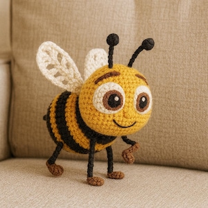 May include: A crocheted bee toy, featuring a yellow body with black stripes and white wings. The bee has large eyes and small antennae. The toy is positioned on a neutral surface, suitable for a child's room or as a decorative item. The toy is made with soft yarn.