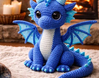 May include: A handmade blue crochet dragon with large black eyes, light blue wings, and horns. The dragon has a white belly and is sitting on a light-colored rug. The background features a fireplace with a burning fire.