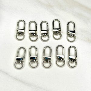 Shiny silver and gold 12x33mm swivel lobster clasps for keychains, bag charms, jewelry making, and DIY craft supplies.